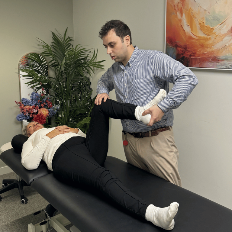 Physiotherapist assessing leg and hip mobility with a patient at physio Nine Elms clinic